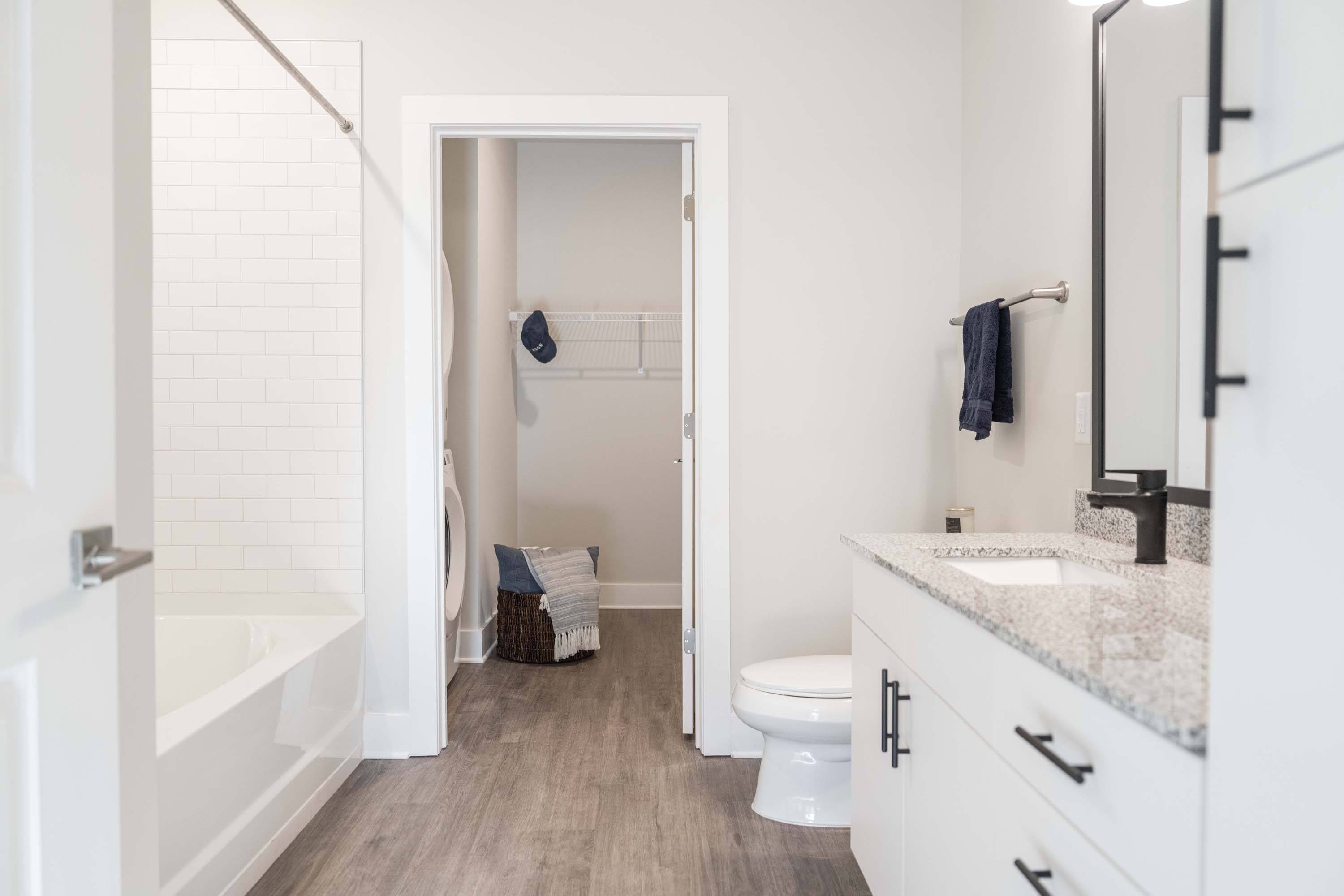 RISE Red Mountain in-unit bathroom with white interior, marble countertop, and wood floor
